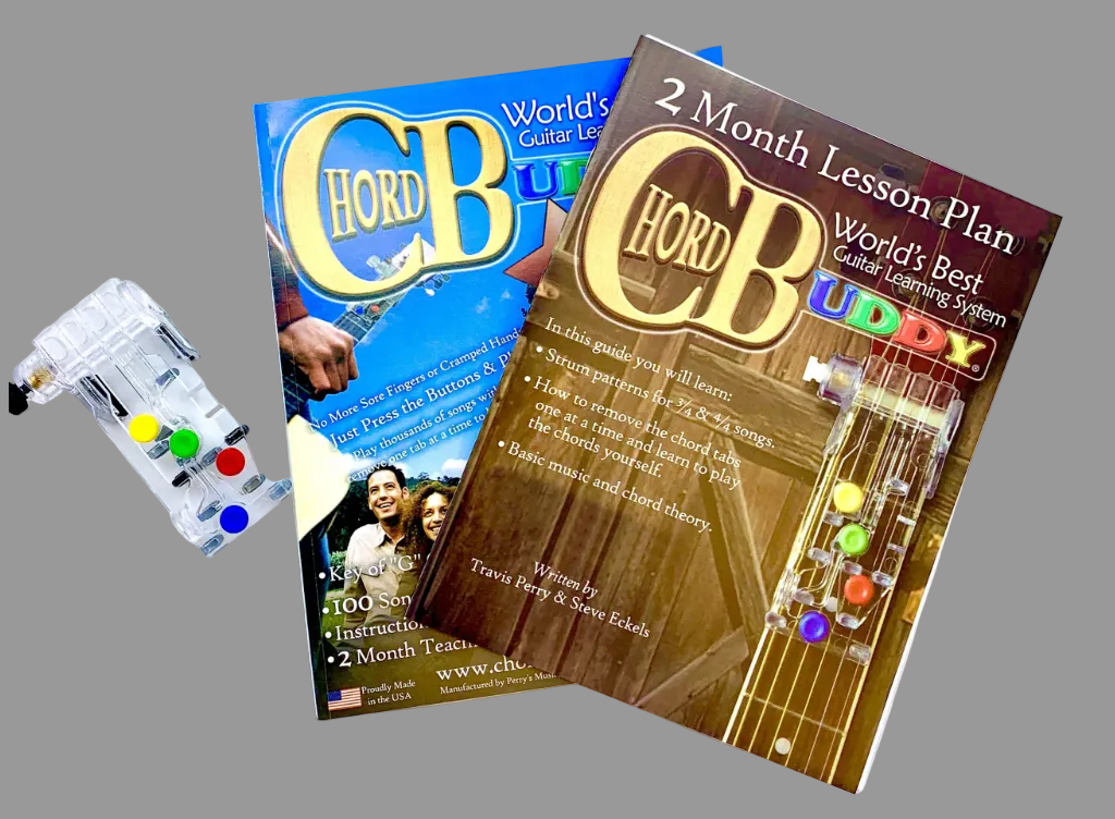 The image shows the ChordBuddy Guitar Learning System which includes a plastic device for guitar learning, a booklet titled '2 Month Lesson Plan', and part of the 'ChordBuddy Song Book featuring 100 Songs'.